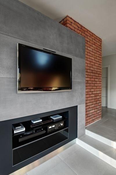 telewizor wiszący na betonowej ścianie